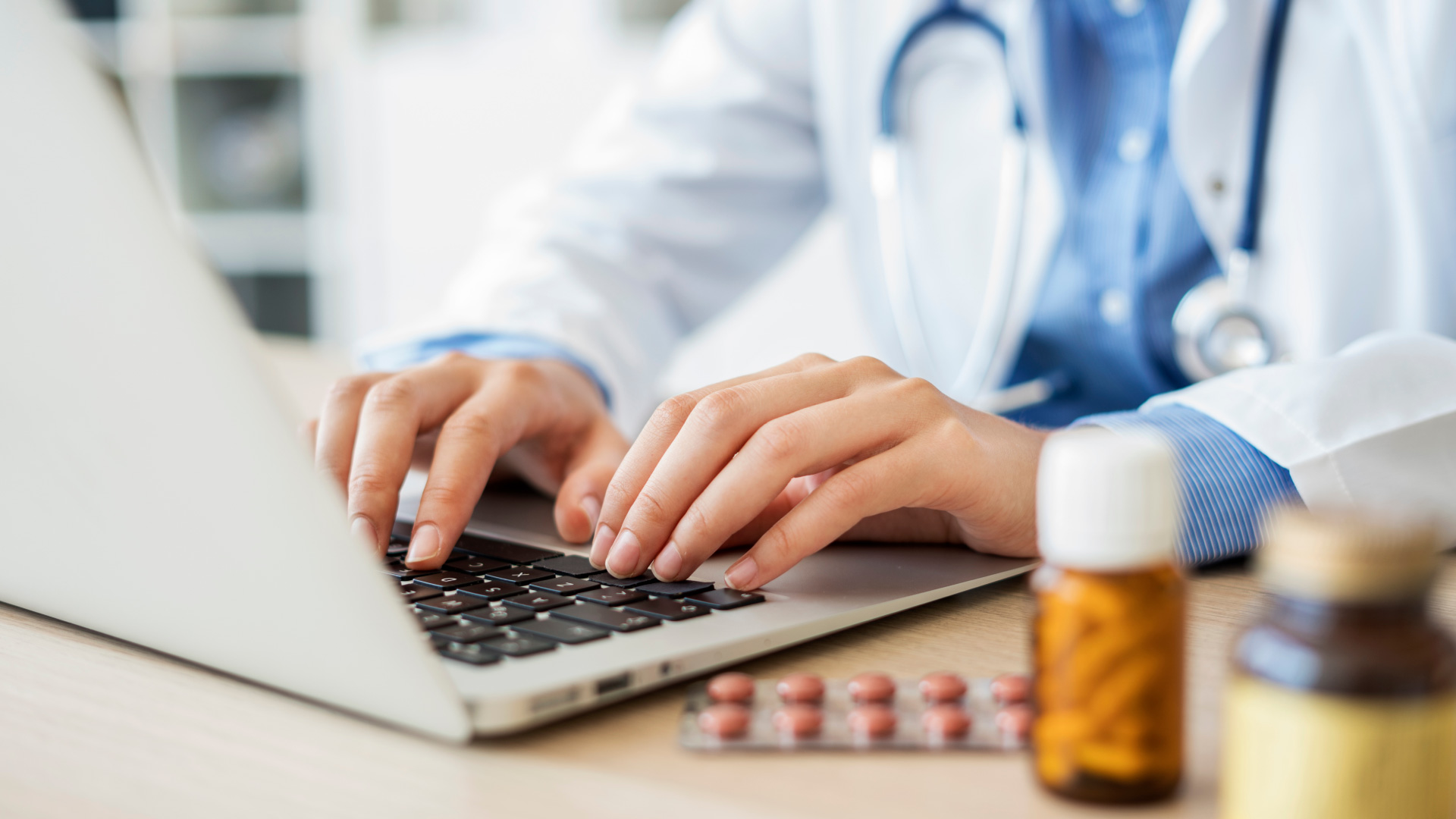 Physician prescribing medication on laptop EHR