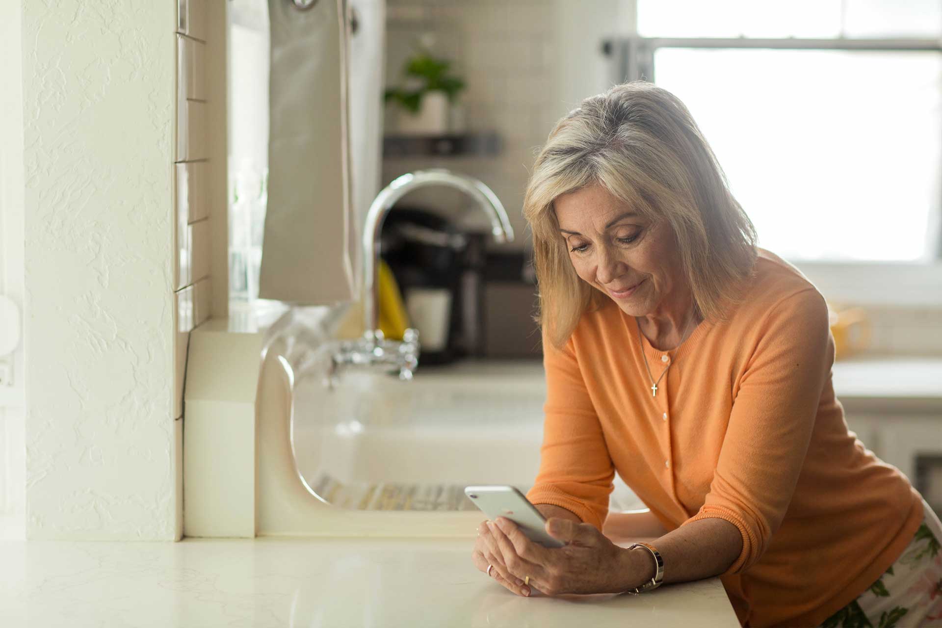 woman texting in the kitchen